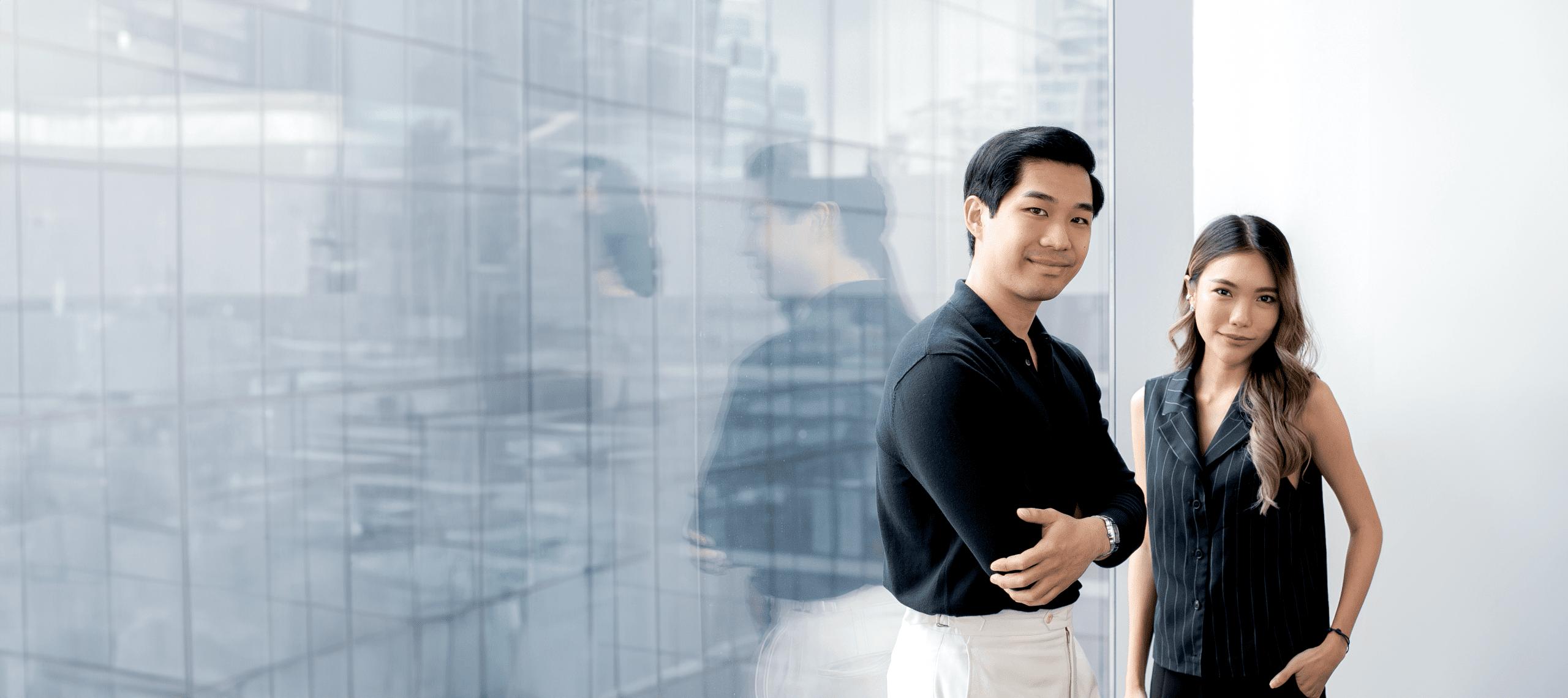 Two Primal strategists standing by a glass office wall